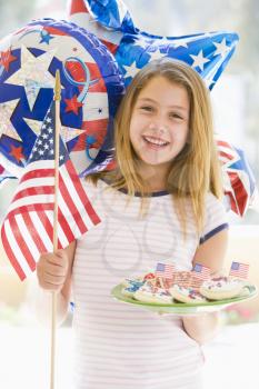 Royalty Free Photo of a Young Girl With an American Flag and a Plate of Cookies