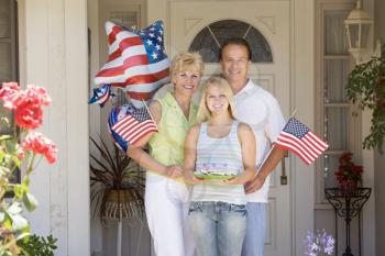 Royalty Free Photo of a Family at the Front Door With American Flags and Cookies