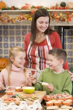 Royalty Free Photo of a Mother With Two Children Making Halloween Treats