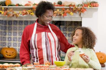 Royalty Free Photo of a Grandmother and Granddaughter Baking Halloween Treats
