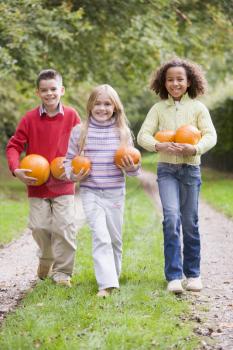 Royalty Free Photo of Children Walking With Pumpkins