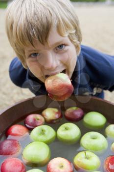 Royalty Free Photo of a Boy Bobbing for Apples