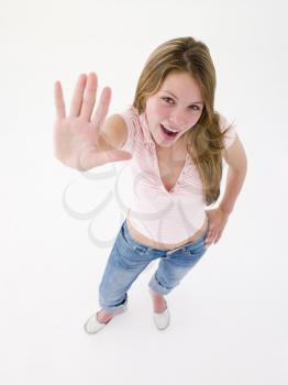 Teenage girl with hand up smiling