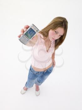 Teenage girl holding up cellular phone and frowning