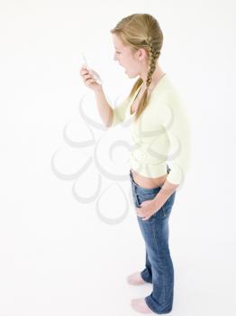 Teenage girl looking at cellular phone in shock