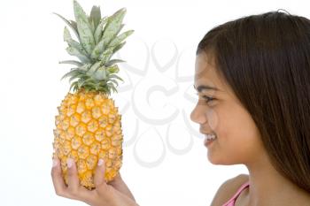 Royalty Free Photo of a Young Girl Holding a Pineapple