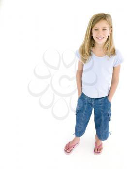 Young girl with hands in pockets smiling