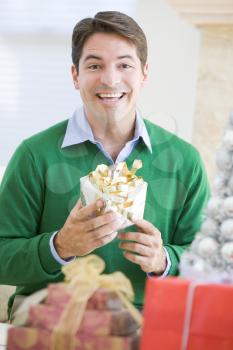 Royalty Free Photo of a Man Opening a Christmas Gift