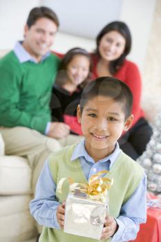 Royalty Free Photo of a Family at Christmas With a Boy Holding a Gift