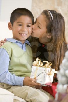 Royalty Free Photo of a Girl Giving a Boy a Gift and a Kiss