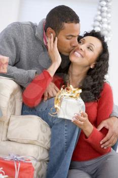 Royalty Free Photo of a Husband Kissing His Wife and Giving Her a Gift