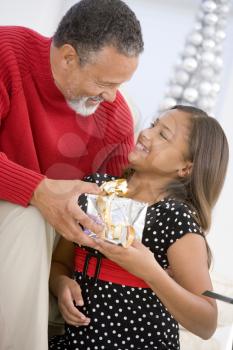 Royalty Free Photo of a Grandfather and Granddaughter With a Gift