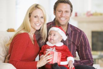 Royalty Free Photo of a Couple With a Baby in a Santa Suit