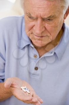 Royalty Free Photo of a Man Looking at Pills