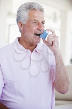 Royalty Free Photo of a Man Using an Inhaler