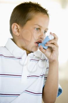 Royalty Free Photo of a Boy Using an Inhaler