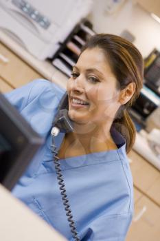 Royalty Free Photo of a Nurse on the Telephone in a Reception Area