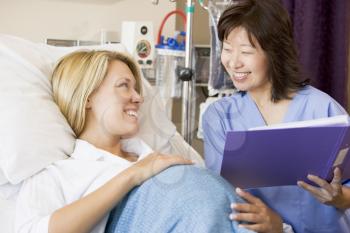Royalty Free Photo of a Pregnant Woman Talking to a Nurse
