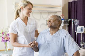 Royalty Free Photo of a Nurse Helping a Patient Sit Up