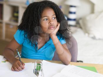 Royalty Free Photo of a Girl Doing Homework and Daydreaming