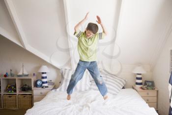 Royalty Free Photo of a Boy Jumping on His Bed