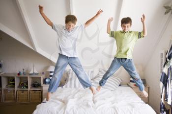 Royalty Free Photo of Two Boys Jumping on a Bed