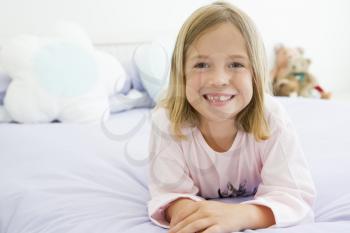 Royalty Free Photo of a Little Girl Lying on a Bed