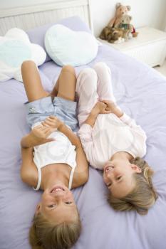 Royalty Free Photo of Two Girls Lying on a Bed