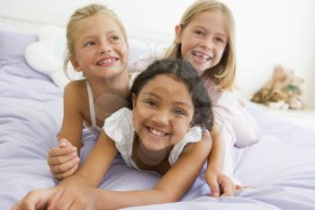 Royalty Free Photo of Three Girls on a Bed