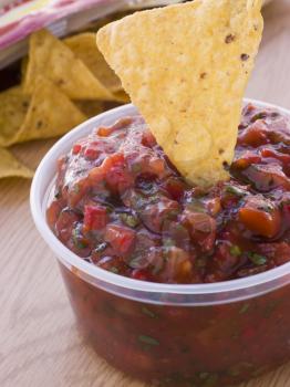 Royalty Free Photo of a Pot Of Tomato And Coriander Salsa With A Corn Tortilla Chip