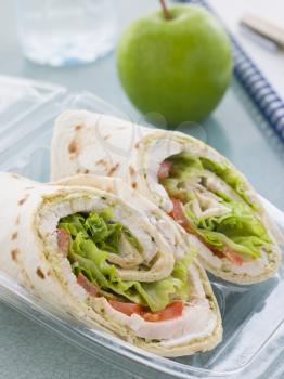 Royalty Free Photo of a Chicken Salad Tortilla Wrap With A Green Apple And Water