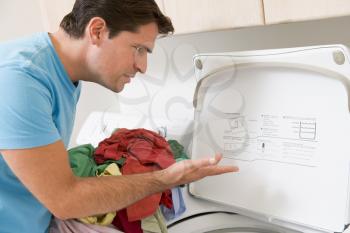 Royalty Free Photo of a Man Confused Doing Laundry