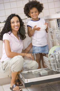 Royalty Free Photo of a Mother and Daughter Loading a Dishwasher