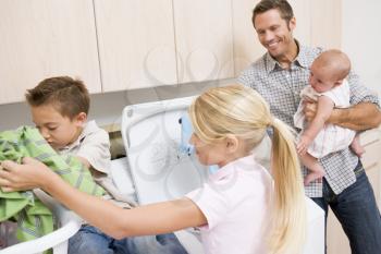 Royalty Free Photo of a Father and Children Doing Laundry