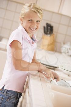 Royalty Free Photo of a Little Girl Doing Dishes