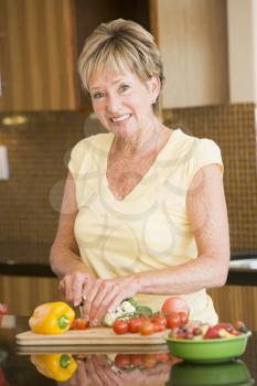Royalty Free Photo of a Woman Cutting Up Vegetables