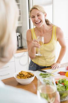 Royalty Free Photo of Two Women Talking While Preparing a Meal