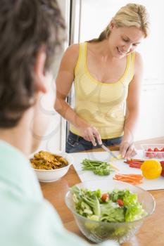 Royalty Free Photo of a Woman Talking to Her Husband While Preparing a Meal
