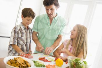 Royalty Free Photo of a Father and Children Preparing Food