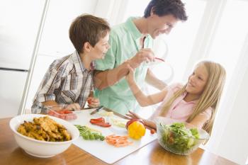 Royalty Free Photo of a Father and Children Preparing Food