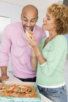 Royalty Free Photo of a Husband and Wife Eating Pizza