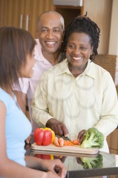 Royalty Free Photo of a Couple Preparing Vegetables With Their Daughter