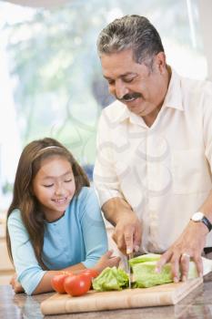 Royalty Free Photo of a Grandfather and Granddaughter Preparing a Meal
