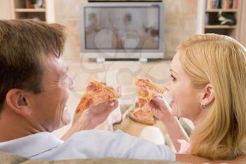 Royalty Free Photo of a Couple Eating Pizza While Watching Television