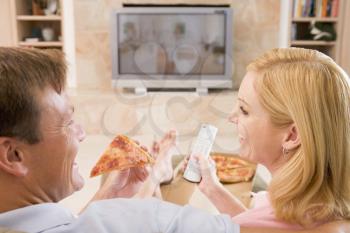 Royalty Free Photo of a Couple Having Pizza While Watching Television
