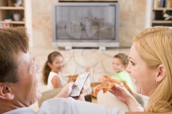 Royalty Free Photo of a Family Eating Pizza in Front of the TV