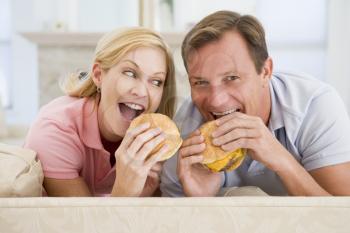 Royalty Free Photo of a Couple Eating Cheeseburgers