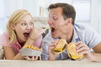 Royalty Free Photo of a Couple Eating Burgers and Fries