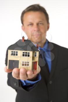 Royalty Free Photo of a Man Holding a Small House