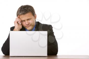 Royalty Free Photo of a Frowning Businessman at a Laptop